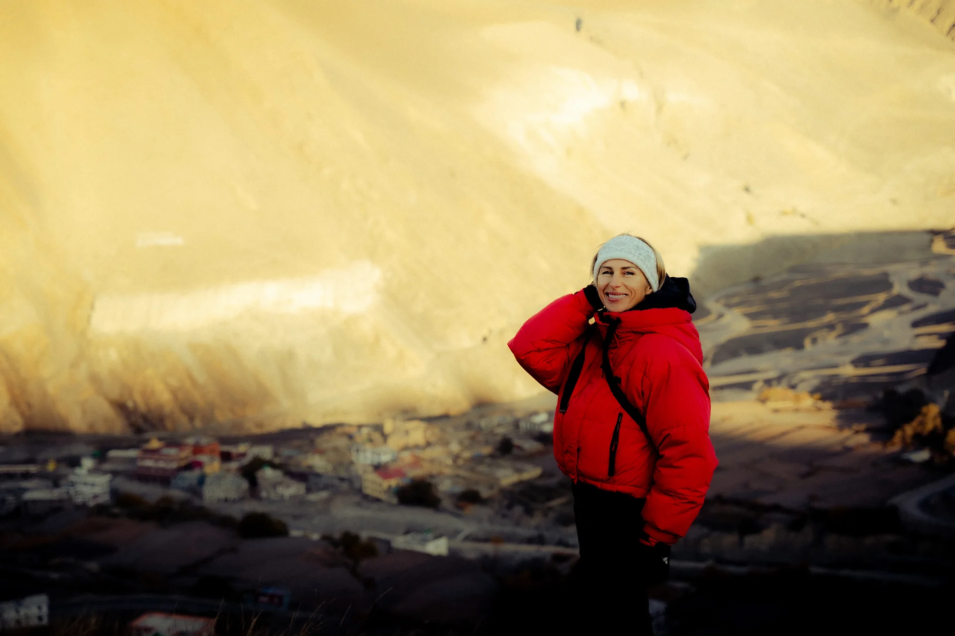 Traveler in a red jacket overlooking a mountain village